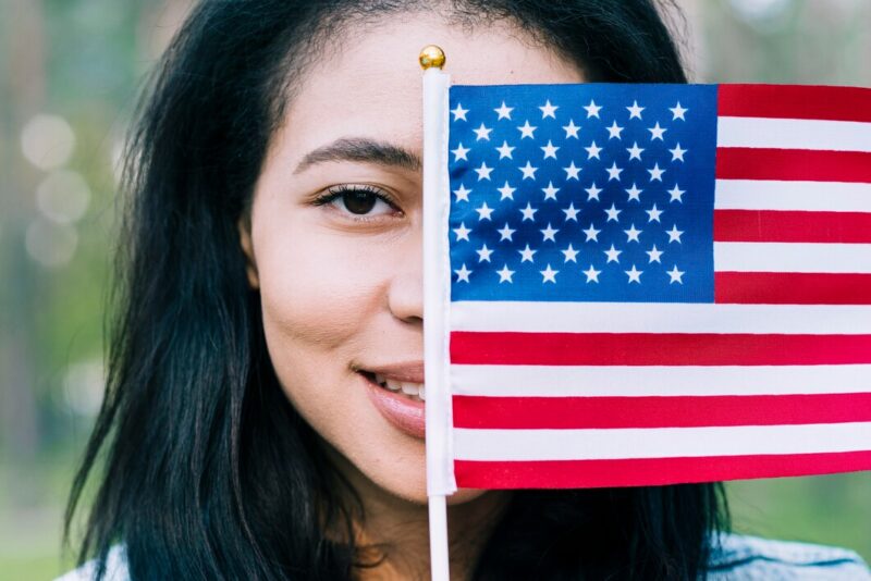 patriotic woman covering face with usa flag 23 2148167001 Cronos Asia