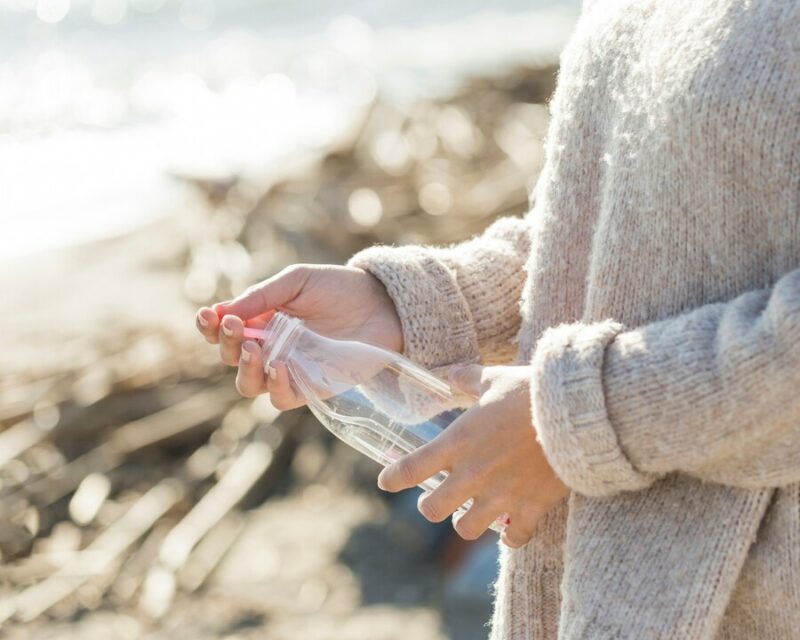 woman picking plastic bottle from sand 23 2148502785 Cronos Asia
